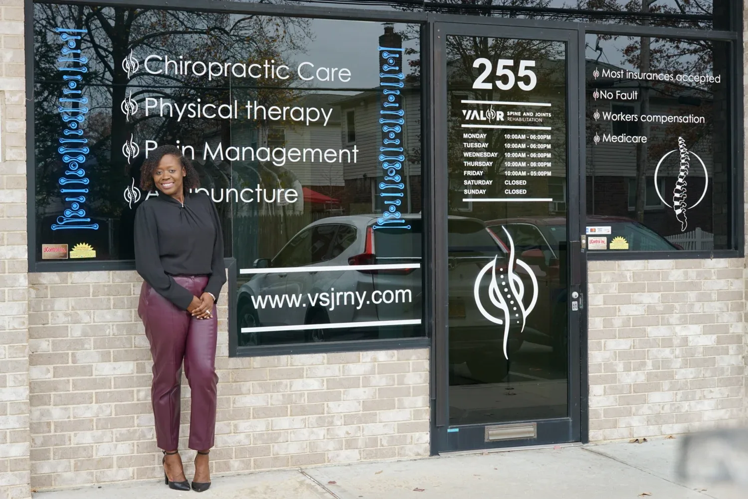 Front windows of VALOR Spine and Joints Rehabilitation listing chiropractic care, physical therapy, pain management and acupuncture
