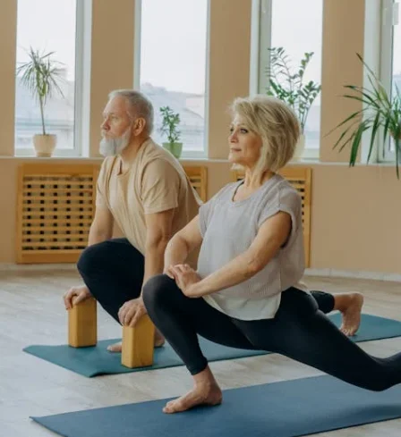 Older adults practicing gentle indoor yoga to help seniors stay active during the colder months.