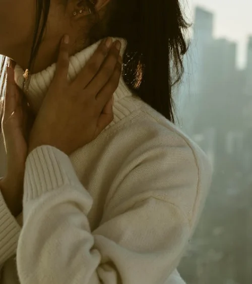 Person experiencing winter aches in the neck and shoulders during cold weather.